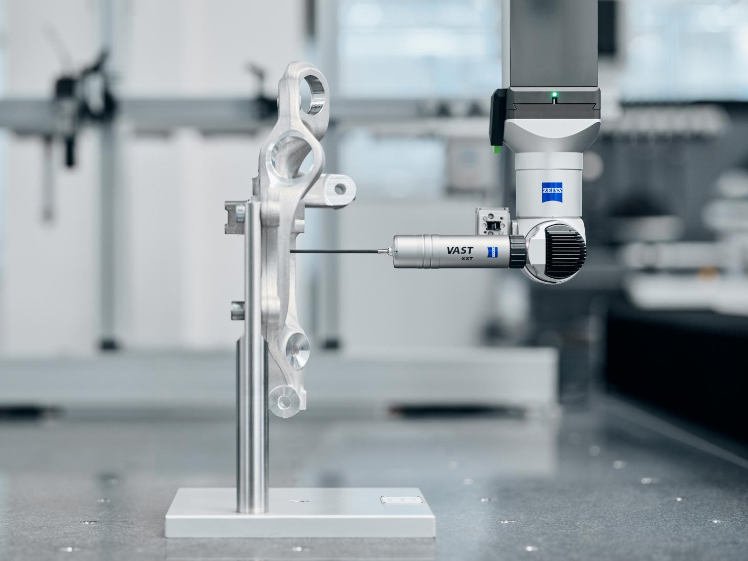 A ZEISS coordinate measuring machine inspects a metallic component using a VAST XXT sensor in a high-precision laboratory setting.