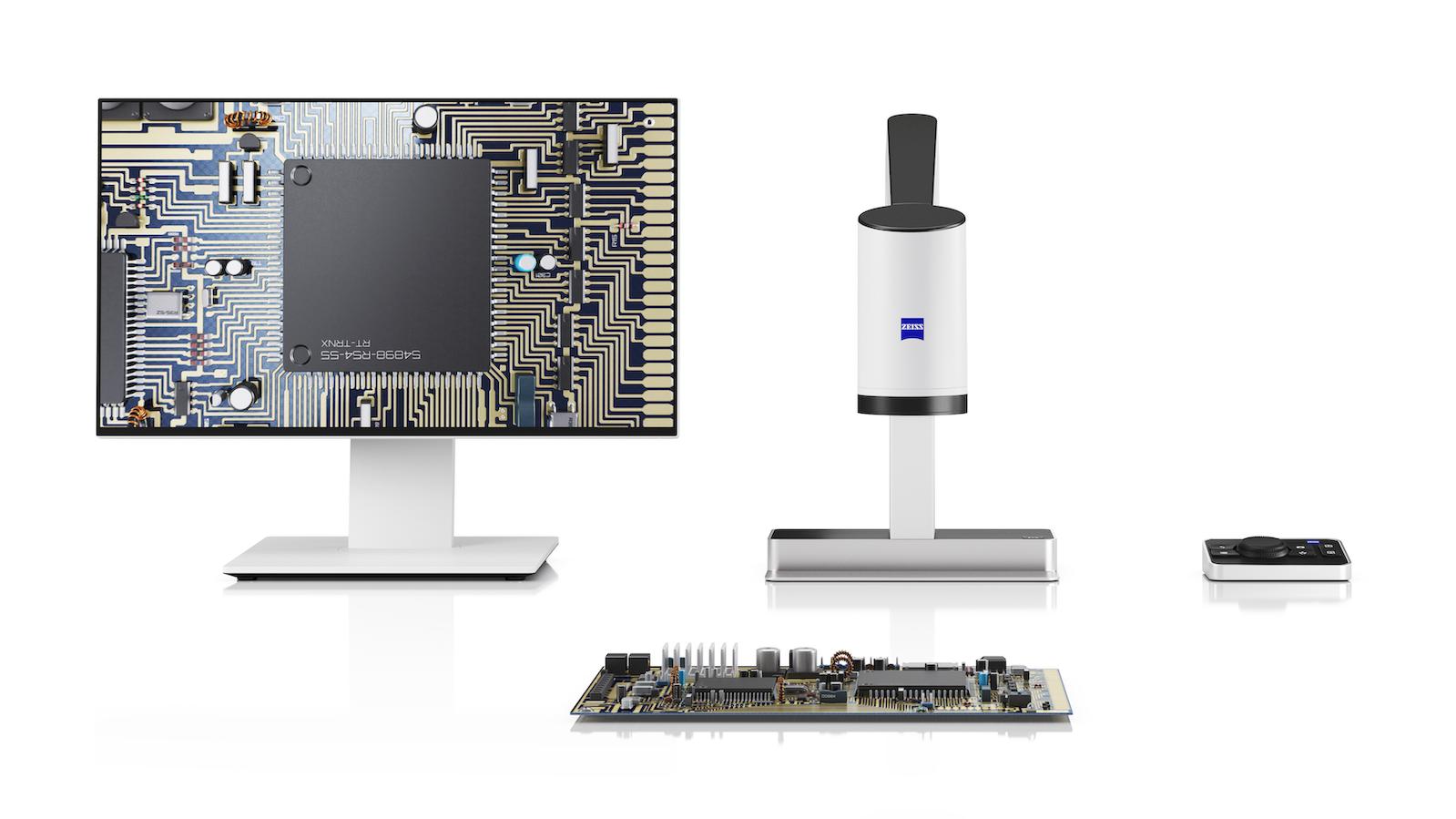 ZEISS digital microscope system setup with a monitor displaying a magnified circuit board, the microscope unit, a control pad, and an electronic component board.