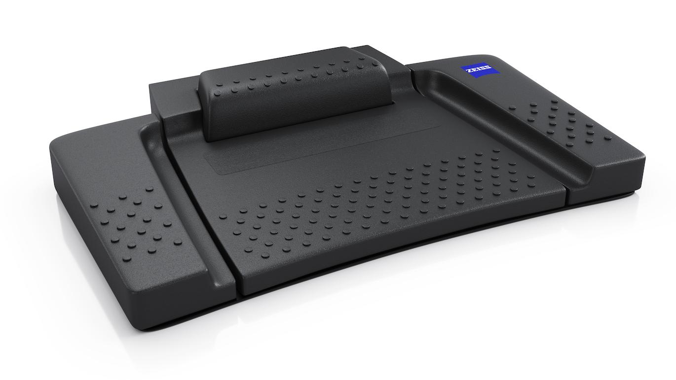 Black ergonomic footrest with textured surface and ZEISS logo on the top right corner.