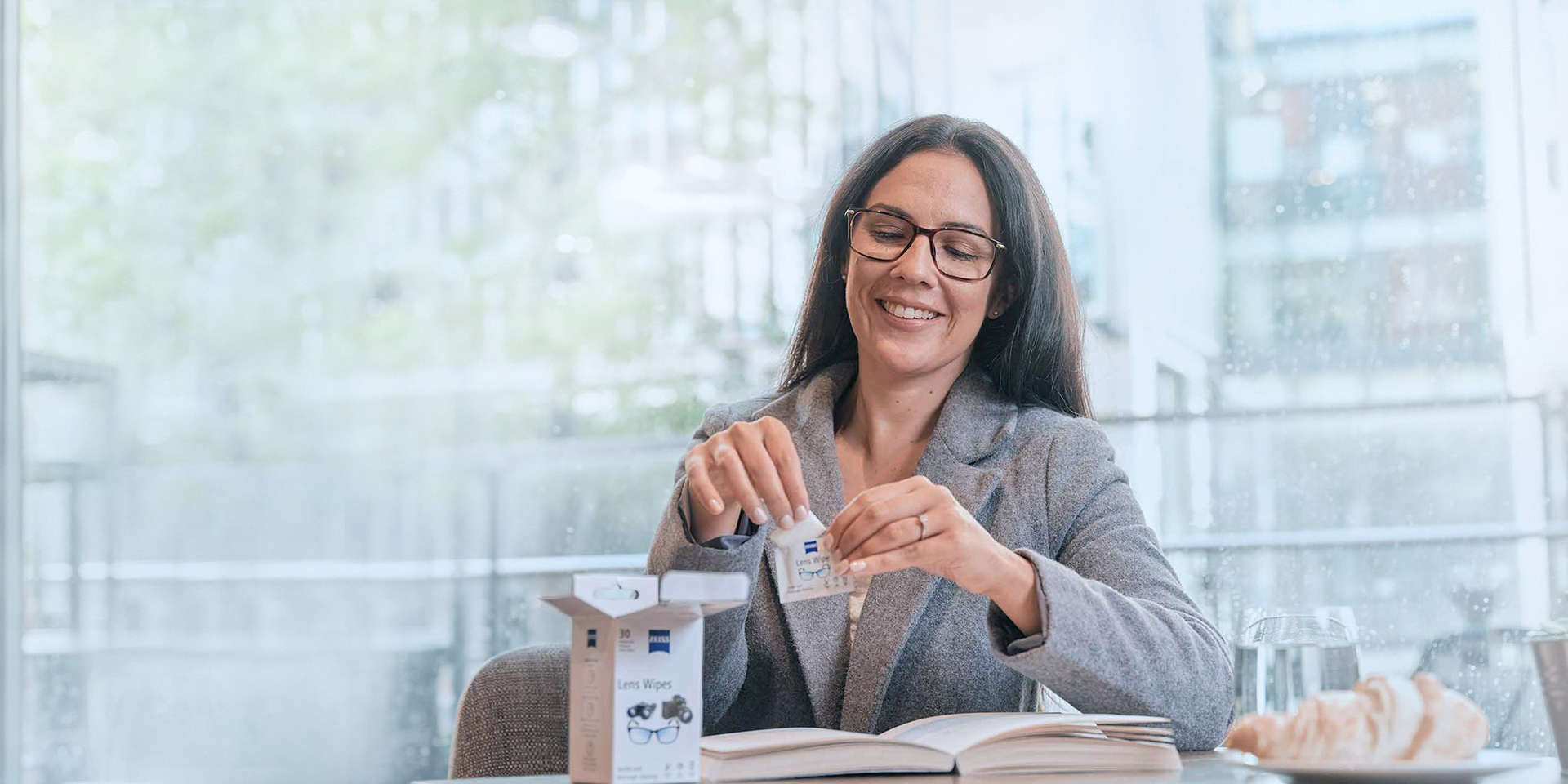 Woman opening wipes sachet for cleaning spectacle lenses