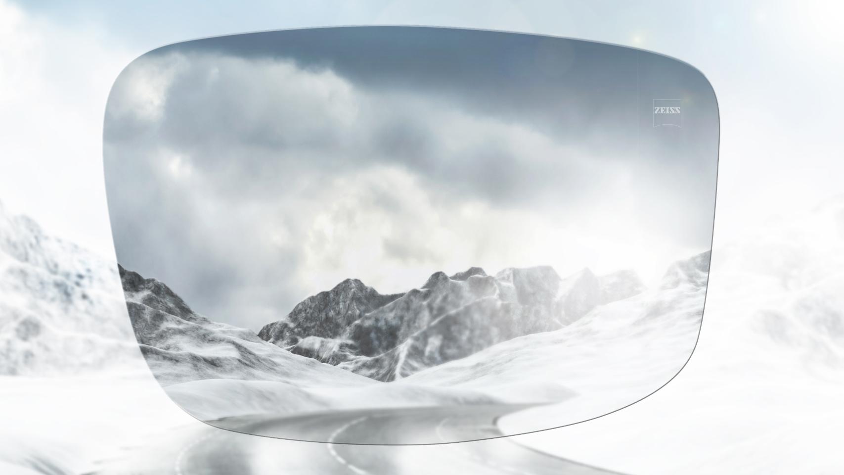 View of a snowy mountain road with and without polarized glasses. With polarized sunglasses glare is reduced for a much clearer view ahead.