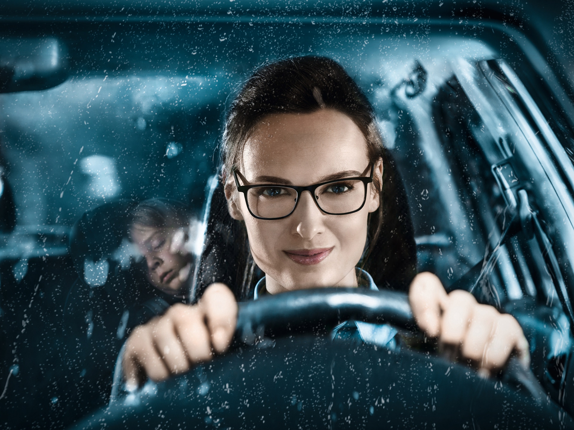 Young attractive woman in glasses driving a car