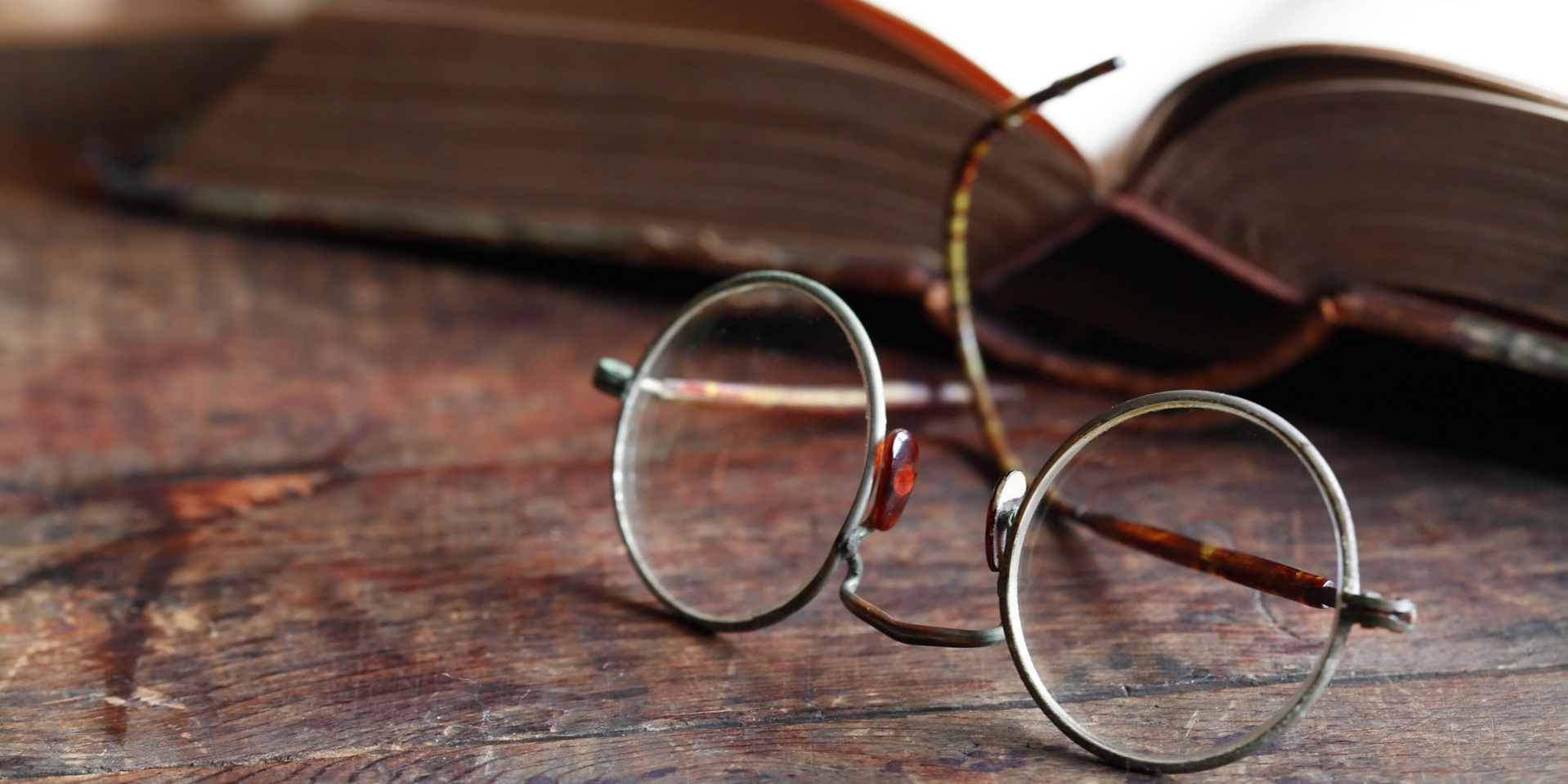 Pair of eyeglasses in front of a book